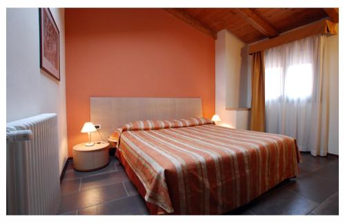 una camera da letto con un letto con pareti arancioni e una finestra di Residence Carlton a Ferrara