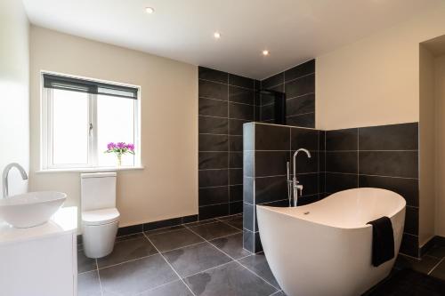 a bathroom with a tub and a toilet and a sink at Bay View House in Kenmare