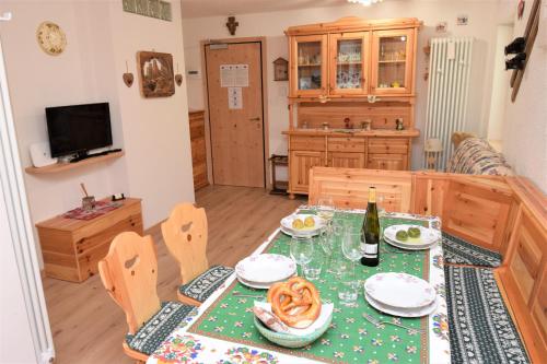 a dining room with a table with a green table cloth at Cësa Valeria e Cësa Giulio in Campitello di Fassa