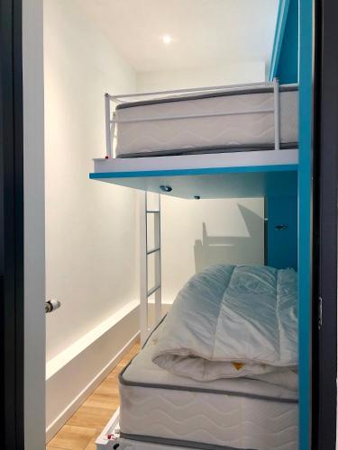 Ce lit superposé se trouve dans un dortoir doté de lits superposés bleus. dans l'établissement Triangle d’or, à Le Touquet-Paris-Plage