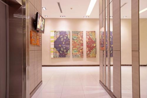 a hallway with paintings on the walls of a museum at Mida Hotel Ngamwongwan - SHA Plus in Nonthaburi