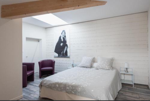 1 dormitorio con 1 cama y 2 sillas moradas en Grand duplex au calme en centre-ville, en Villefranche-sur-Saône