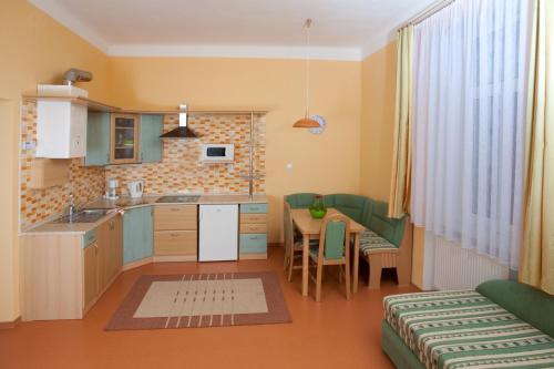 uma cozinha com uma mesa e uma sala de jantar em Homely Apartments Villa Christiana em Mariánské Lázně