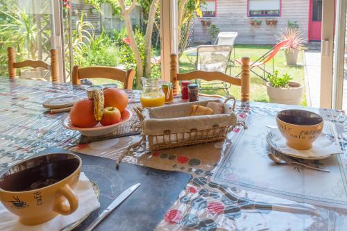 una mesa con desayuno de café y fruta en ella en L'Escale Marine - Couette et Café, en La Rochelle