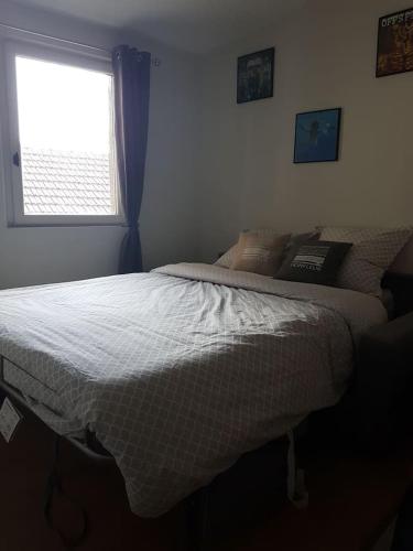 une chambre avec un lit et une fenêtre dans l'établissement Le Rock Studio, à Honfleur