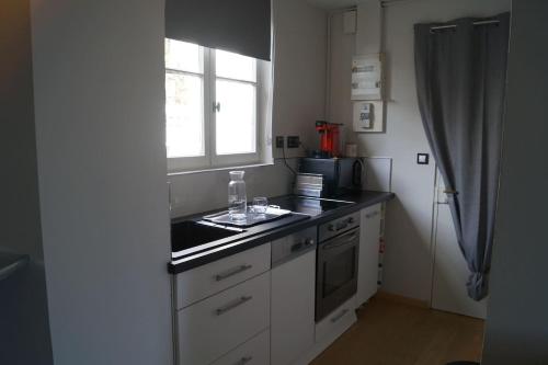 a kitchen with a sink and a window at Le Rock Studio in Honfleur