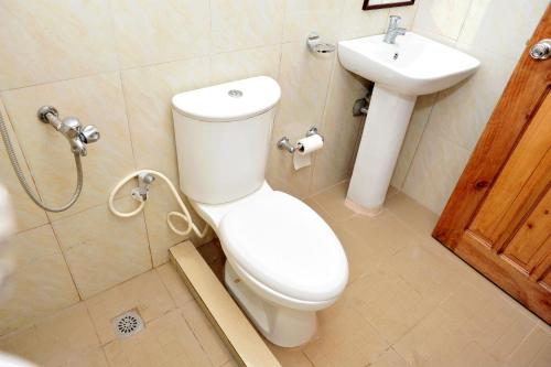 a bathroom with a toilet and a sink at Casa Bicolandia Suites in Daraga