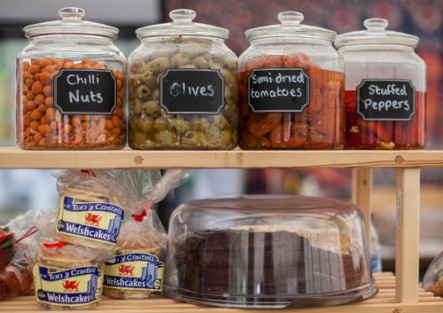 a display of jars of pickles and vegetables on a shelf at Glamping at Hay Festival in Hay-on-Wye