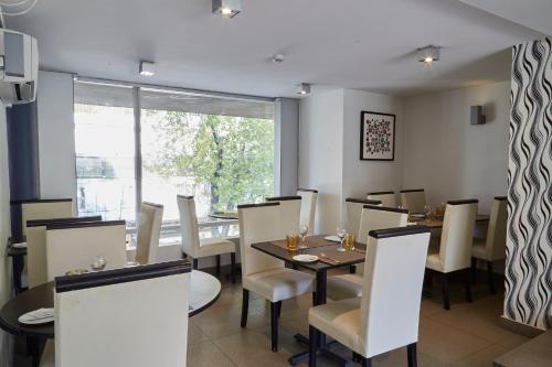 a dining room with tables and chairs and a window at Hotel Terrado Providencia in Santiago