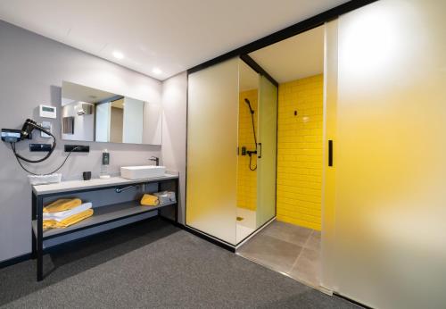 uma casa de banho com uma porta amarela e um lavatório em Nest Style Valencia em Valência