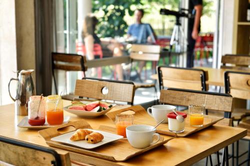 a wooden table with breakfast foods and drinks on it at Artemisia Boutique Hotel in Bastelica