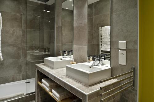 a bathroom with two sinks and a mirror at Boutique Hotel Artemisia in Bastelica