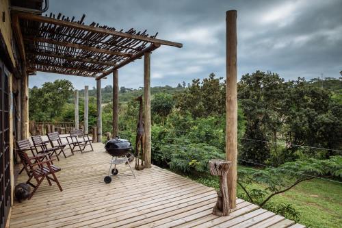 una terraza de madera con sillas y una parrilla. en Eloff Guest House and Gallery, en White River