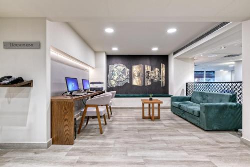 an office with a couch and a desk with a computer at The Stanley in Athens