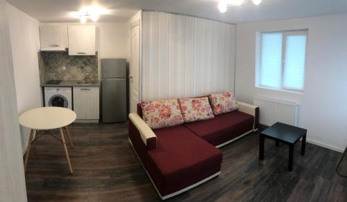 a living room with a couch and a table and a kitchen at Stanford Aparthotel in Bucharest