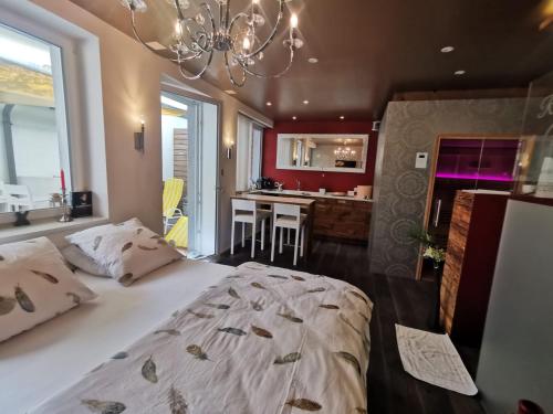una camera da letto con un grande letto e un lampadario a braccio di Private Spa am Rennweg a Amriswil