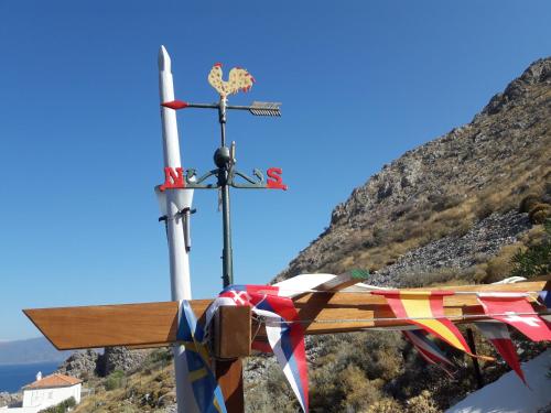 a cross on top of a mountain with flags on it at Hydra Erato in Hydra