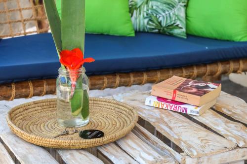 um vaso com uma flor sentado numa mesa com um livro em B4 Beach Club em Paje