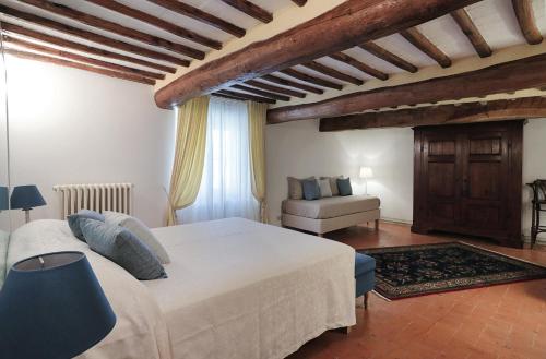 um quarto com uma grande cama branca e um sofá em Suite Testamatta em Pisa
