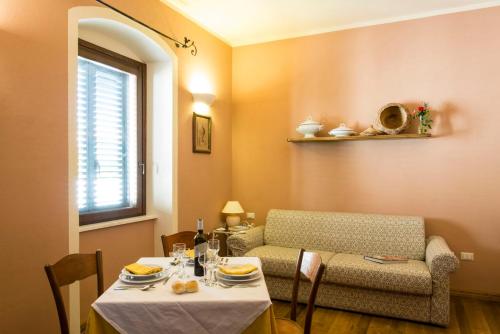 a living room with a table and a couch and a table and chairs at Hotel Villa Gli Asfodeli in Tresnuraghes