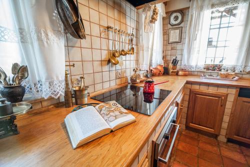 a kitchen with an open book on a counter at Authentic Countryside Villa with Hot tub in Veliki Kamen