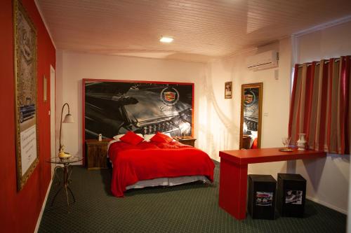 a bedroom with a red bed with a car on the wall at Pousada Serra Azul in Urubici