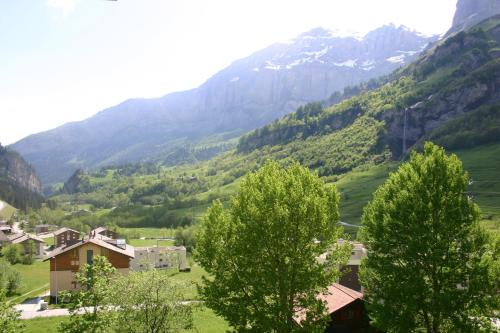 a village in a valley with mountains in the background at Alfa Appartements Superior in Leukerbad