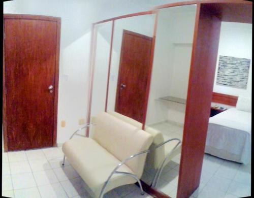 a room with a chair and a bed and a mirror at Campus Liberdade Flat in Belo Horizonte
