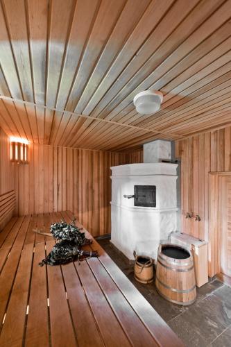 a room with a fireplace and a wooden ceiling at Ami Residence Forest in Didžiasalis