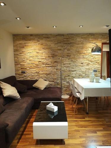 a living room with a couch and a table and a brick wall at Apartamento a 1a linea Sant Llorenç de Montgai_ WhiteHouse in Sant Llorenç de Montgai