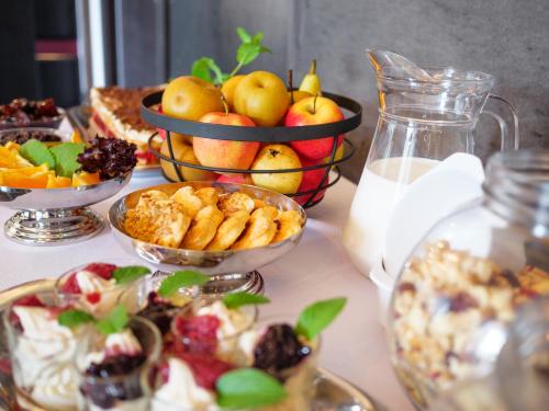 a table topped with bowls of fruit and desserts at Rezydencja Eger in Kazimierz Dolny