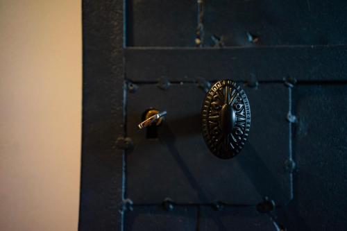a black door with a metal door knocker on it at Gite Amélie, Sauna, Spa au coeur des Vosges in Housseras
