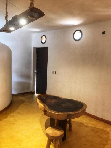 a wooden table in a room with two stools at Cuarto de Tim in Mazunte