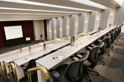 a long row of tables and chairs in a room at DoubleTree by Hilton New York-LaGuardia in Queens