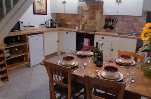 a kitchen with a table with plates and wine glasses at Gites Limousin - La Haute in Videix