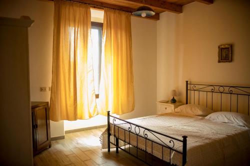 una camera con letto e finestra con tende gialle di Casa Cortes a Desulo