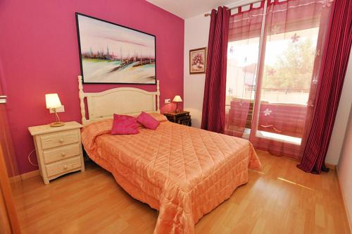 a bedroom with a large bed with purple walls at 1095 Aquamarina in Roses