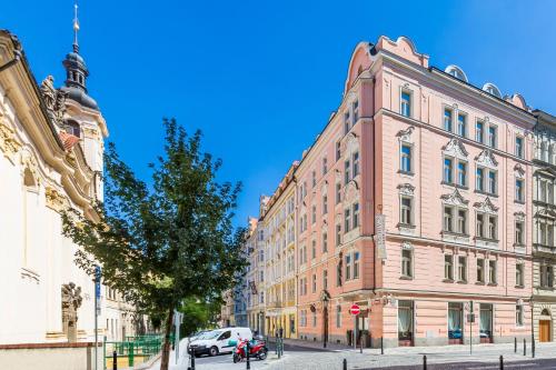 a large pink building on a city street at Hotel Caruso Old Town in Prague
