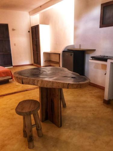 a large wooden table in a kitchen with two stools at Cuarto de Tim in Mazunte