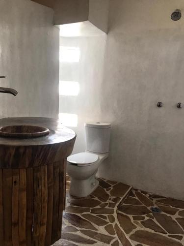 a bathroom with a toilet and a wooden sink at Cuarto de Tim in Mazunte