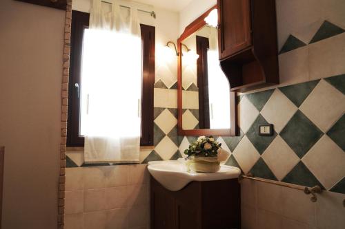 Appartamento Sardegna في بورتو سان باولو: حمام مع حوض ونافذة