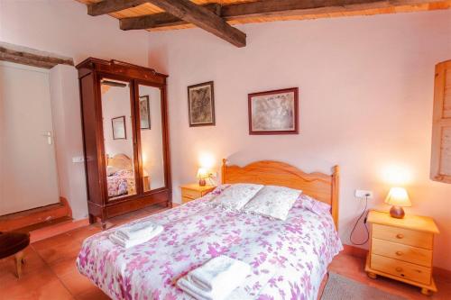 une chambre avec un grand lit et deux lampes dans l'établissement El Paller del Molí de la Plana, à Riudaura