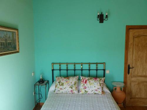 um quarto azul com uma cama e uma parede azul em El Carro del Abuelo em Villovela de Pirón
