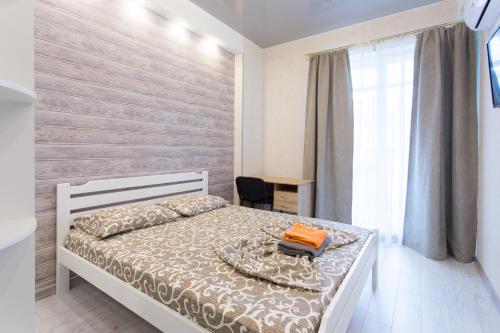 a bedroom with a bed and a desk and a window at Naykova district Apartments in Kharkiv