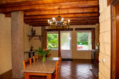 a dining room with a table and chairs and a chandelier at Geres Nature House, casa das pedras in Vieira do Minho