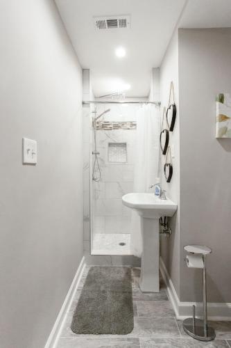a white bathroom with a shower and a sink at Lavish Living - 8 mins from Braves Stadium w/King in Smyrna