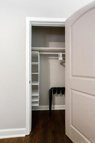 a closet with white shelves and a door at Lavish Living - 8 mins from Braves Stadium w/King in Smyrna