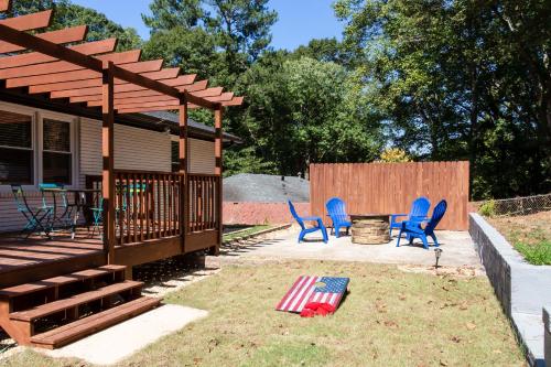 a patio with blue chairs and a table and a deck at Lavish Living - 8 mins from Braves Stadium w/King in Smyrna