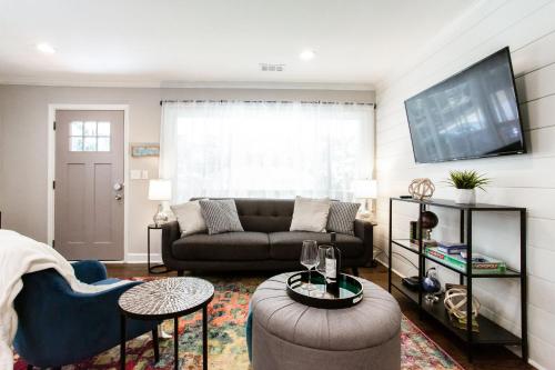 a living room with a couch and a tv at Lavish Living - 8 mins from Braves Stadium w/King in Smyrna