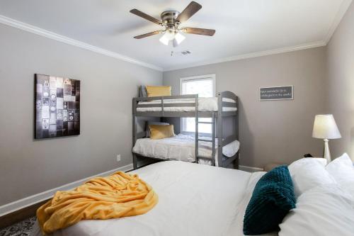 a bedroom with two bunk beds and a ceiling fan at Lavish Living - 8 mins from Braves Stadium w/King in Smyrna